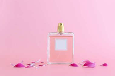 Pembe pastel arka planda zarif bir parfüm şişesi resmi