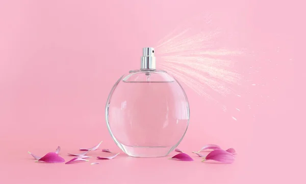 Obraz Eleganckiej Butelki Perfum Opryskującej Różowe Pastelowe Tło — Zdjęcie stockowe