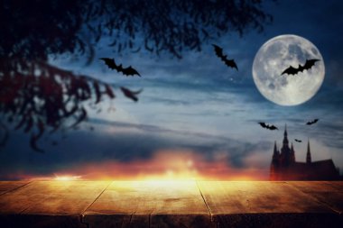 Cadılar Bayramı tatili konsepti. Korkunç ve sisli gece gökyüzünün, ormanın ve dolunayın önündeki boş köy masası. Ürün görüntüleme kurgusu için hazır