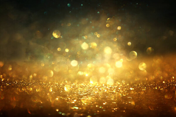 Background of abstract gold and black glitter lights. defocused