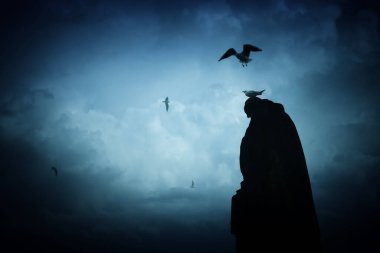 Bulutlu gökyüzünde karanlık gotik heykel görüntüsü