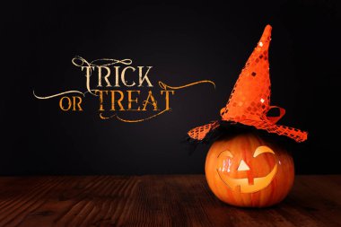 Cadılar Bayramı konsepti imajı. Ahşap masa ve siyah arka plan üzerinde balkabağı