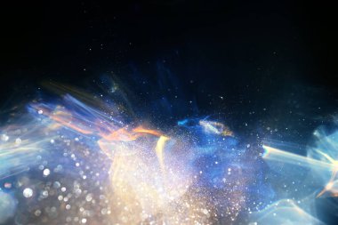 Altın ve mavi merceğin arka planı yanıp sönüyor. Soyut resim