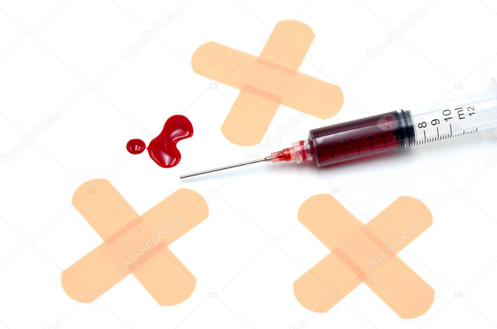 syringe with blood and adhesive plaster on white background