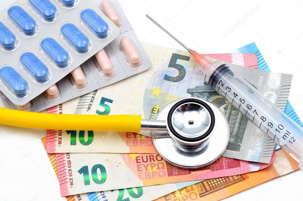 syringe with money and stethoscope medicine close up
