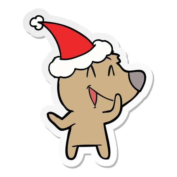 Laughing bear sticker cartoon of a wearing santa hat — Stock Vector