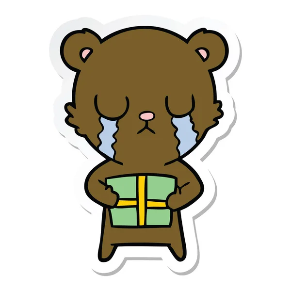 Наклейка плачущего медведя с подарком — стоковый вектор