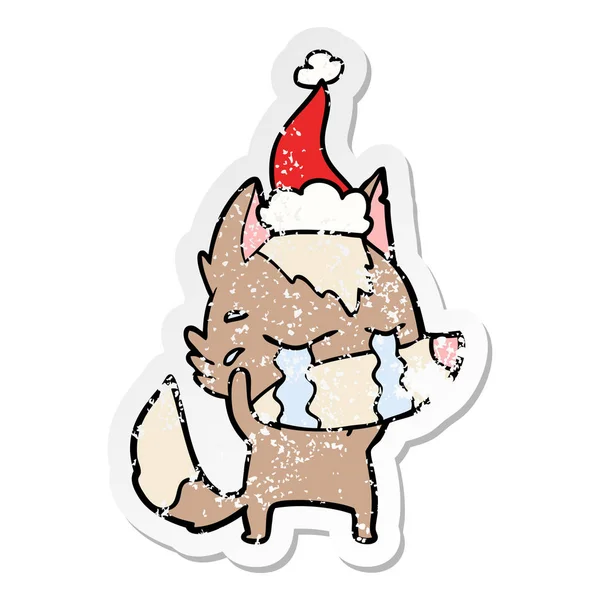 Distressed sticker cartoon of a crying wolf wearing santa hat — Stock Vector