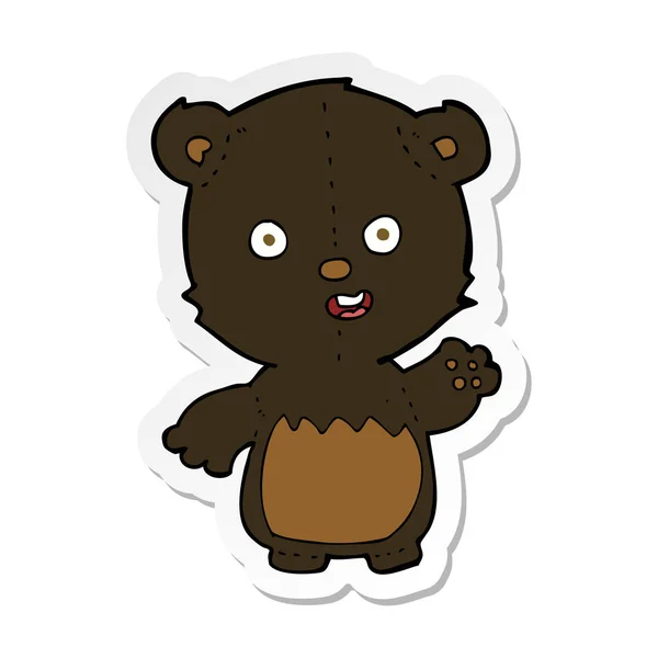 Etiqueta de um desenho animado acenando filhote de urso preto — Vetor de Stock