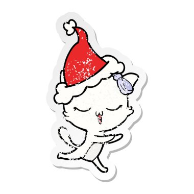 el sıkıntılı etiket karikatür bir kedi yay ile santa şapka kafasına çekilmiş.