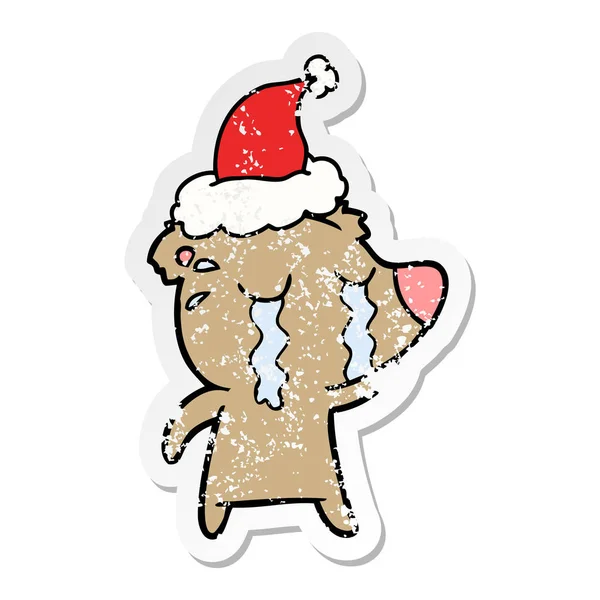 Aufkleber Karikatur eines weinenden Bären mit Weihnachtsmütze — Stockvektor