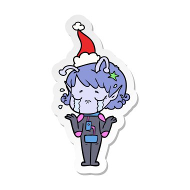 etiket karikatür Noel Baba şapkası giyen ağlayan bir uzaylı kızın el çekilmiş