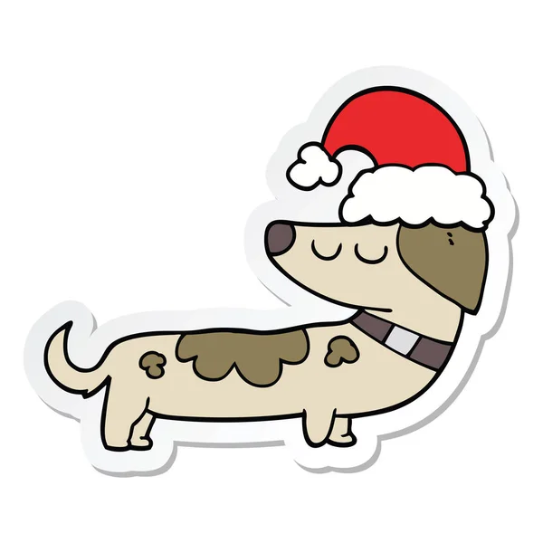 Autocollant d'un chien de dessin animé portant un chapeau de Noël — Image vectorielle