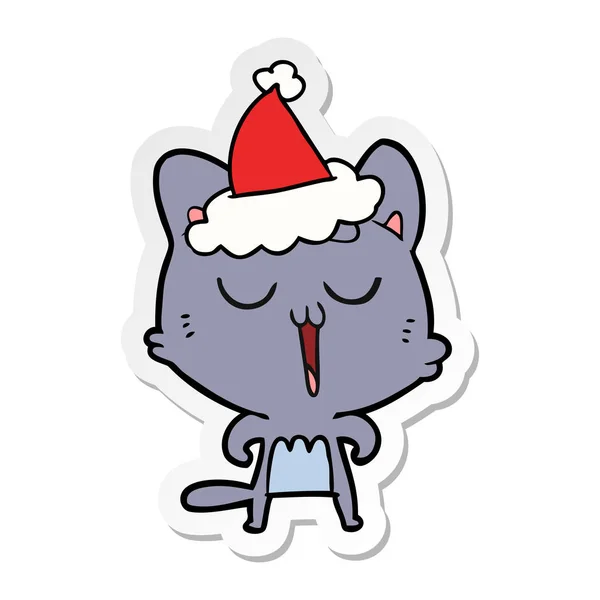 Autocolant desen animat de o pisică cântând purtând pălărie Moș Crăciun — Vector de stoc