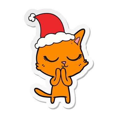 elle çizilmiş etiket karikatür Noel Baba şapkası giyen bir kedi sakin