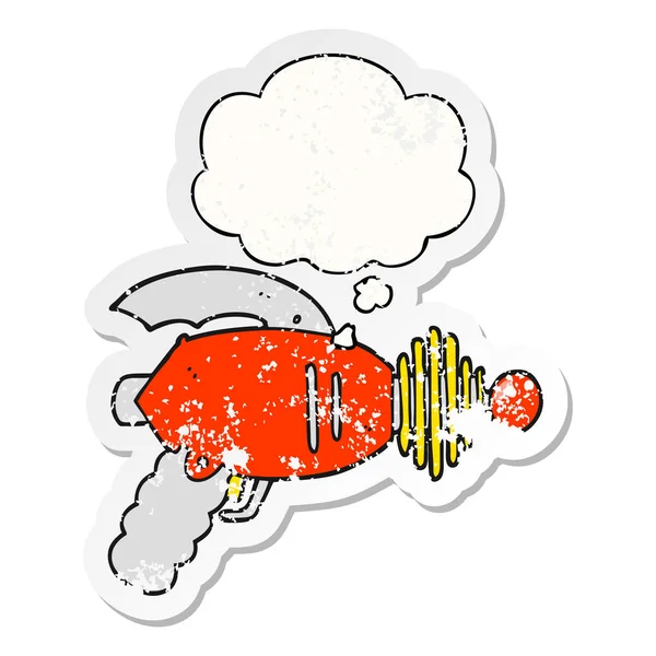 Cartoon Ray Gun en dacht Bubble als een verdrietig versleten sticker — Stockvector