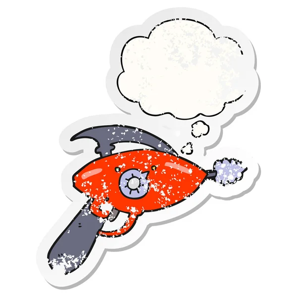 Cartoon ray gun and thought bubble as a distressed worn sticker — Stock Vector