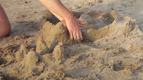男が川で砂の城を構築します — ストック動画