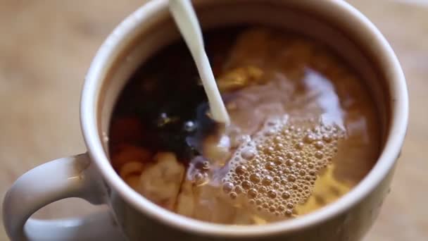 Verser le lait dans le café dans une grande tasse 