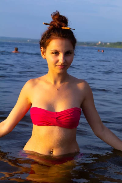 Pembe bikini ayakta ve suda poz güzel seksi kız