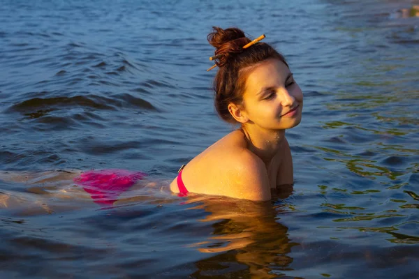 ピンクのビキニで美しいセクシーな女の子が泳ぐとポーズ — ストック写真