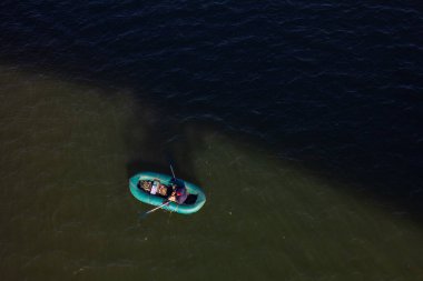 Nehirde yüzen bir teknede bir balıkçı