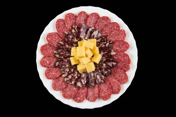 Beyaz bir tabak ve karanlık bir arka plan üzerinde peynirli sosis