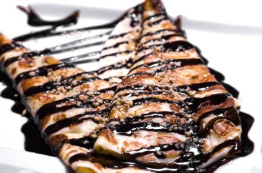 Çikolatalı topping, fındık ve beyaz bir tabağa doldurma tatlı ile krep