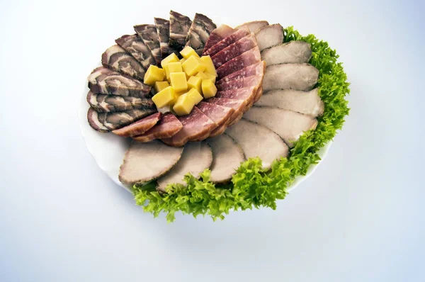 Meat roll, sausage, baked meat and cheese on a light background