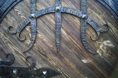 Koyu tonlarda dekoratif dövme elemanları ile ahşap kapı