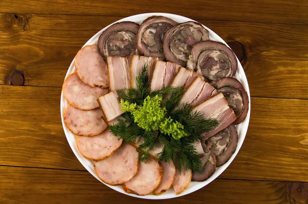 Bacon, roll and sausage, decorated with salad and dill