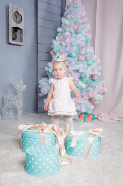 Sevimli küçük bir Avrupa Sarışın Prenses kız güzel bir elbise hediye oyuncak ve Noel ağacı Noel temalı dekore edilmiş bir stüdyo açma bir taç ile portresi