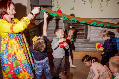 Rusya, Yaroslavl - 03 Şubat 2017: mutlu çocuk doğum günü kutlaması, grup tarzı giyinmiş eski Rus peri masalı animatör kızla yarışmalar ve oyunlar büyük odada kiler ve soba ile.