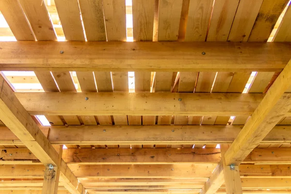 wooden interior frame of a new house under building, architectural residential construction stick built home framework.