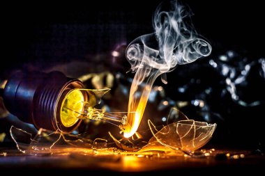 Ampul parçalanmak duman ve kırık cam parçaları ile ayrı tut siyah arka plan üzerine yanan inanılmaz patlama. yaratıcı sanat illüstrasyonlar tungsten filaman yanma hava ile temas halinde kavramı