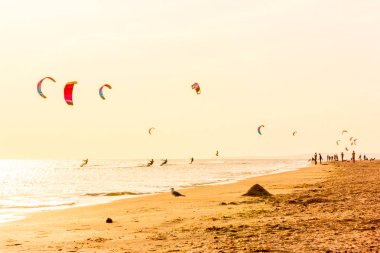 aşırı grup kiters binmek dalgaların yelken kanat liderliğindeki elinde ile Karadeniz üzerinde havada atlar bir günbatımı onlookers fotoğrafçılar martı kıyısında ile Rüzgar. duyuru köyü. arkadan aydınlatmalı ve tonda.