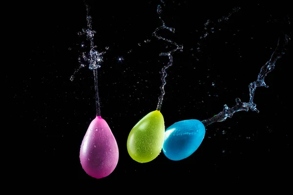 Amazing explosion big water color balloon bomb with splash  water on isolated  black background with flash. concept of freezing moment of time.