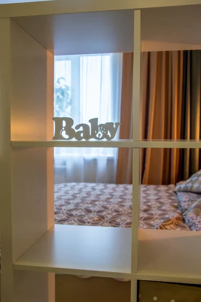 モダンな家のインテリアリビングルームの装飾要素と正方形のラックと白い赤ちゃんのレタリングと空のアパートの豪華な家具のセグメント — ストック写真