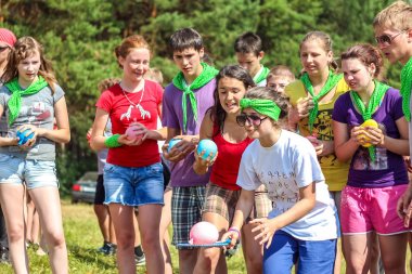 Rusya, Yaroslavl - 30 Haziran 2012: grup mutlu çocuklar ve yetişkin gençler yaz orman çadır kampında dinlenmek bankalar Volga nehir üzerinde aktif oyunlar oynamak parlak Güneşli gün yarışmalara katılmak