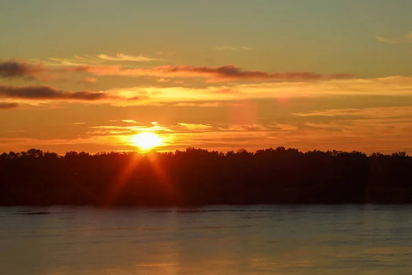 太陽のまぶしさとヴォルガ川の夏の太陽のオレンジ色の光のハイライトと美しい深い朝の夜明け オレンジ色とバックライトでトーン — ストック写真
