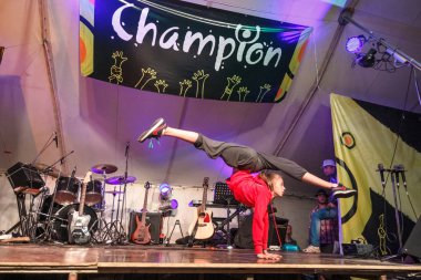 Rusya, Yaroslavl - 03 Temmuz 2014: Sahnede tiyatro prodüksiyonuna katılan esneklik egzersizleri gösteren kız jimnastikçinin performansı ışıkla müzikal ve dans konseri etkinliğine katılıyor