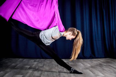 Rusya, Yaroslavl - 16 Aralık 2018: esnek kız sinek fitness hamaklar, hava yoga halatlar ve asılı eğitim için sınıfta daha önce ısınma.