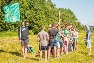 Rusya, Yaroslavl - 30 Haziran 2012: grup mutlu çocuklar ve yetişkin gençler yaz orman çadır kampında dinlenmek bankalar Volga nehir üzerinde aktif oyunlar oynamak parlak Güneşli gün yarışmalara katılmak