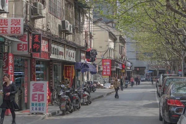 Shanghai, Çin. Yol. Bina. Trafik. Teller. Sokak. İşaretler. İnsanlar. Motorlu bisikletler. Bisiklet. Nisan, 2013