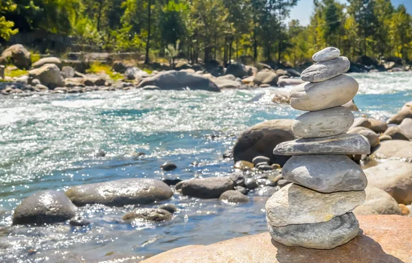 Balance and wellness retro spa concept, inspiration, zen-like and wellbeing tranquil composition. Close-up of white pebbles stack balanced stones on the rocky shore over near river side.