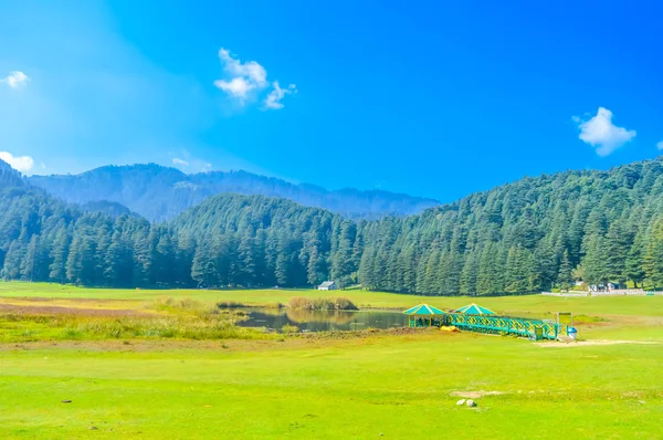 A beautiful golf course on a hill station with road blue sky trees clouds. Captured in sunny day hill station India taken landscape style useful for background wallpaper screen saver Vacation Concept