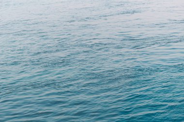 Görünümü temiz akan mavi su yüzeyi dalgalanmalar ve yapraklara veya güneş ışığı yansımaları ile. Güzel Adriyatik Denizi su alacakaranlıkta ışıkta parlar. Doğal güzellik için arka plan dalga su doku tasarım.