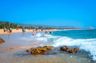 Goa, Hindistan, 6 Mayıs 2017: Seçici odak: genç tanımlanamayan turist tatil yaz yürüme ve Noel tatili sırasında oynayan insanlar grubu. Manzara görünümü kıyı şeridi. Seyahat hedef sahne.