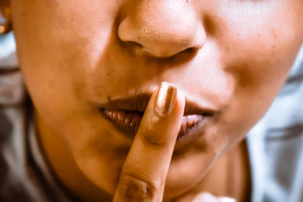 finger on lips close up, silence gesture. Shut up, shut mouth, no talking facial expression sign or symbol. Young adult fashion model gesturing on isolated background.