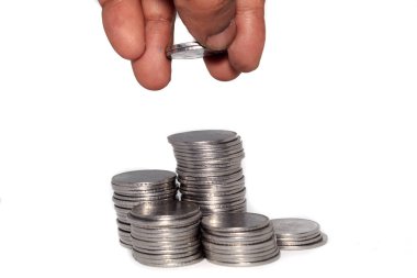 Bir işadamı madeni paraların üstüne para koyuyor. Finansal, ekonomik, yatırım ve tasarruf kavramı. Bankacılık ve takas objesi. Görüntüyü kapat.
